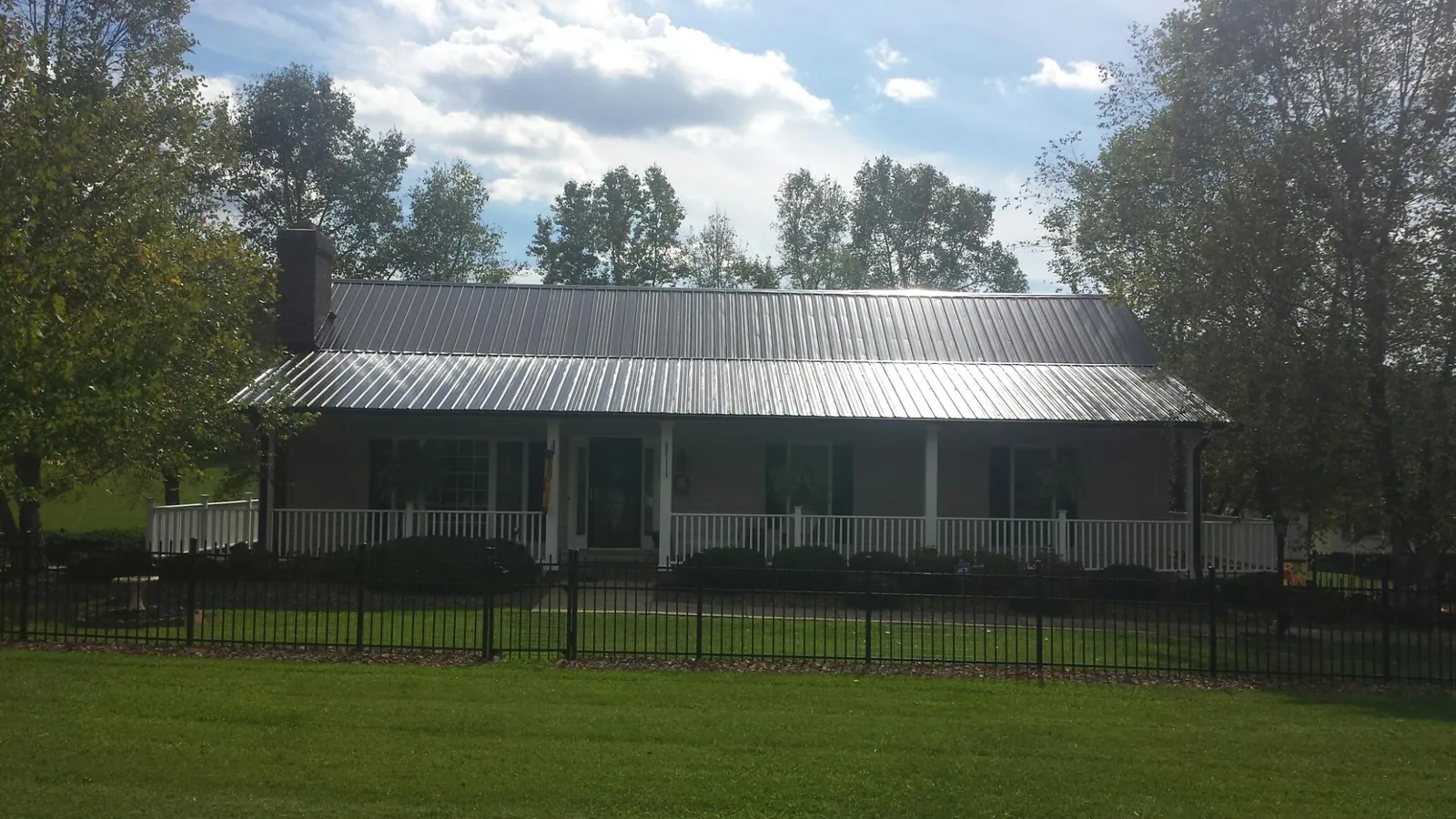 Gray metal roof on a brick ranch with a full width front porch in Worcester